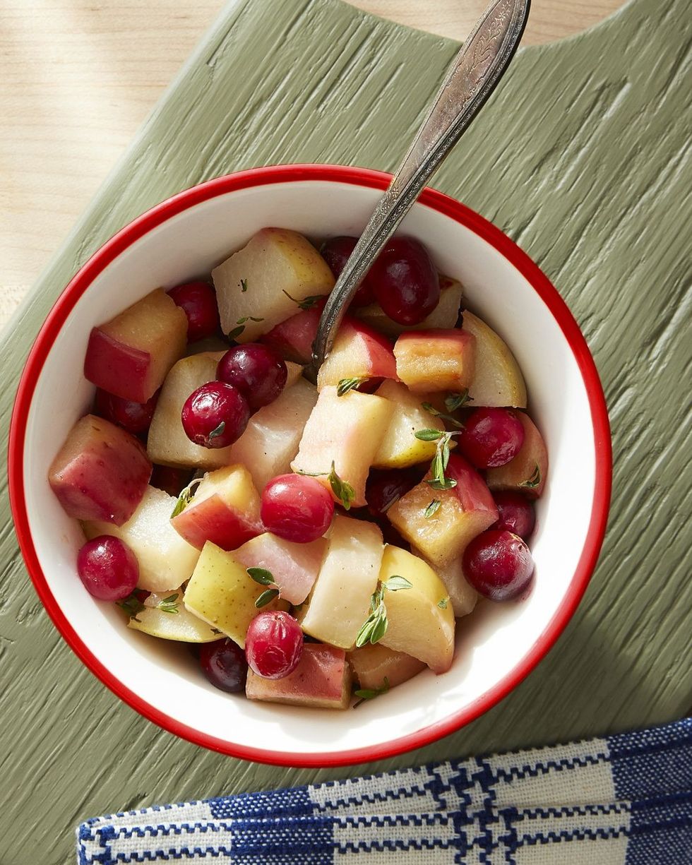 sauteed apples pear cranberries in a bowl with a spoon