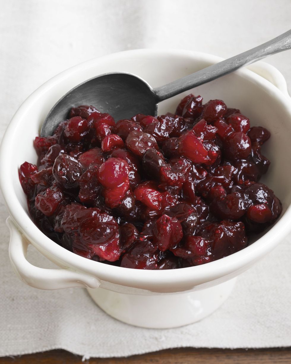 cranberry and dried cherry sauce in a white serving bowl with a spoon