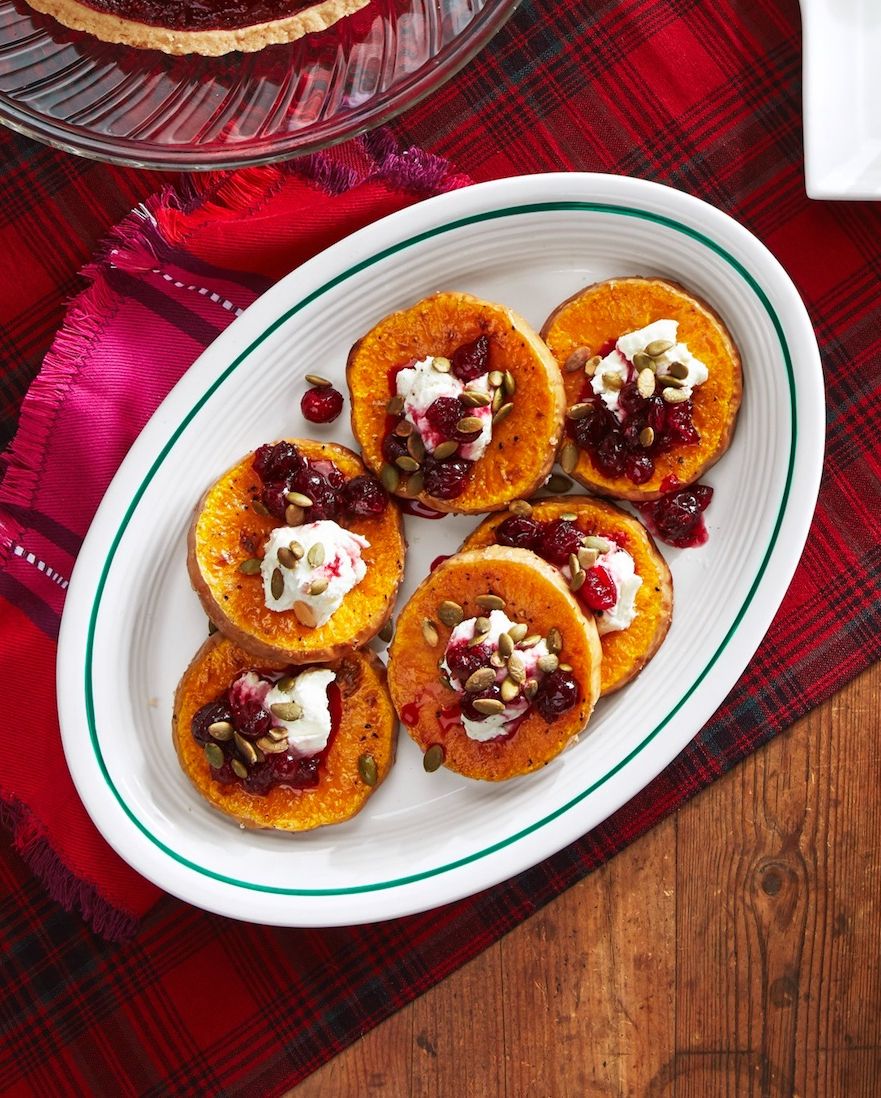 roasted squash with goat cheese and poached cranberries arranged on an oval serving plate