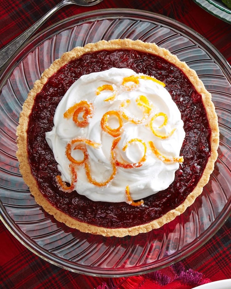 cranberry tart with whipped cream and candied orange zest on top