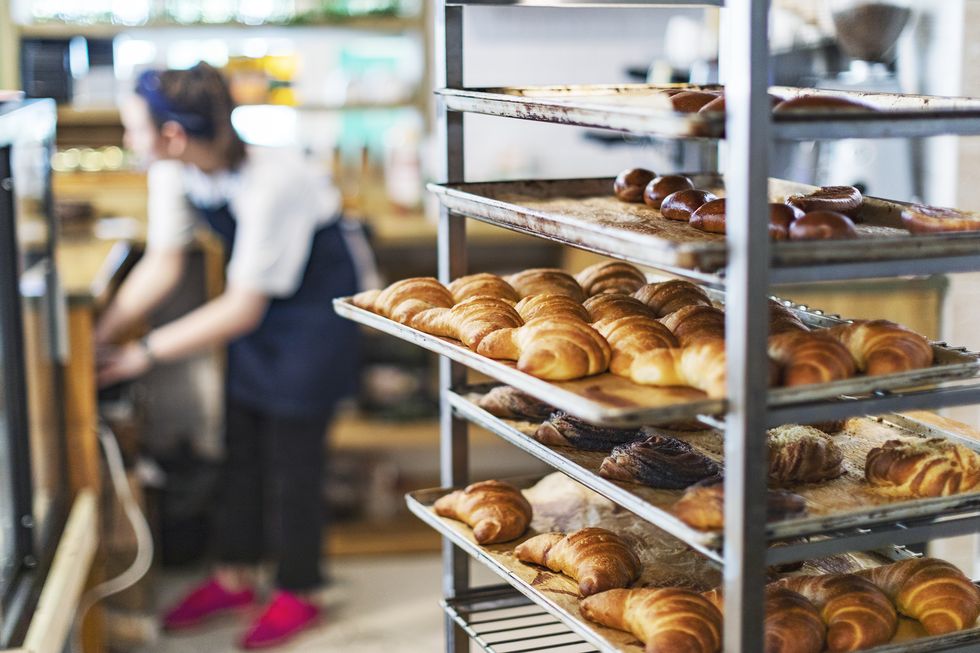 fresh french bread and croissants in a bakery in cooling rack