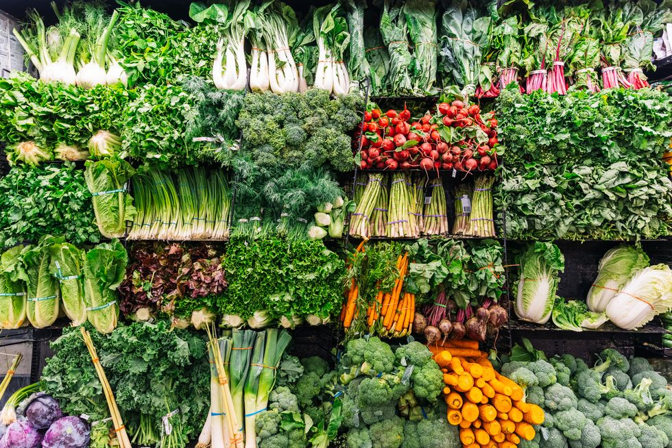 fresh greens and vegetables on a display in a supermarket