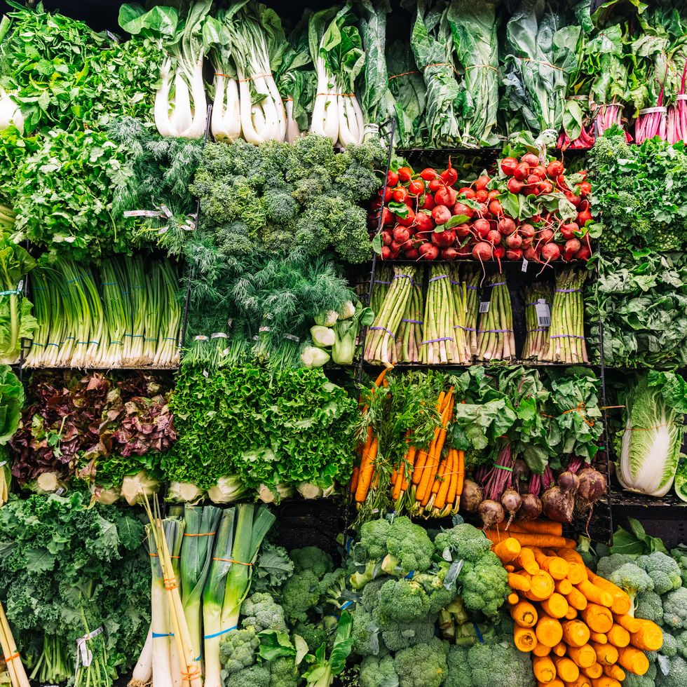 fresh greens and vegetables on a display in a supermarket