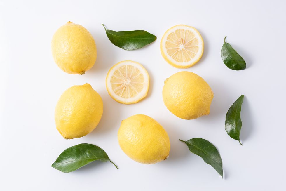 fresh lemons with leaves on white background