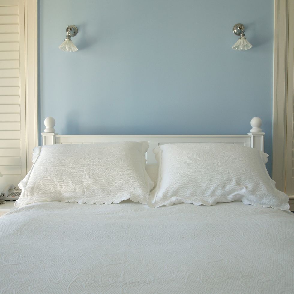 fresh linens on the bed of in a robin's egg blue bedroom