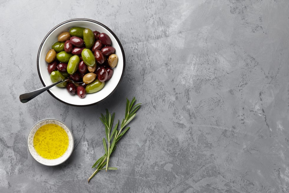 fresh olives in a bowl with olive oil and rosemary