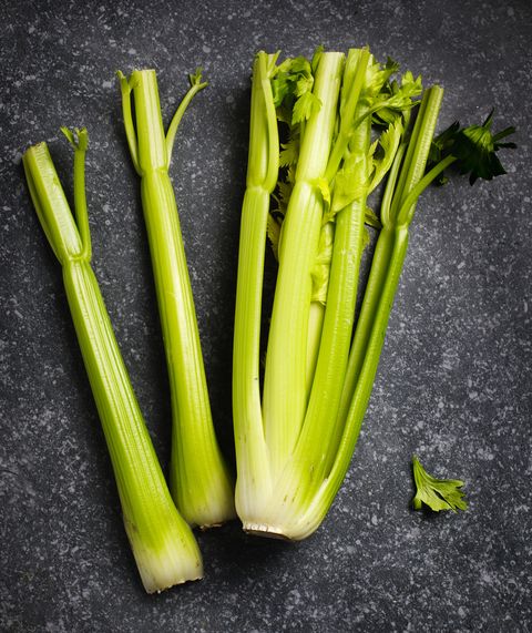 Fresh organic celery on dark grey stone background