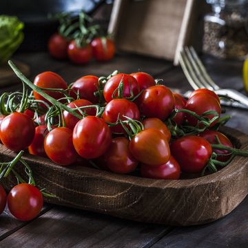 fresh organic cherry tomatoes shot on rustic wooden table
