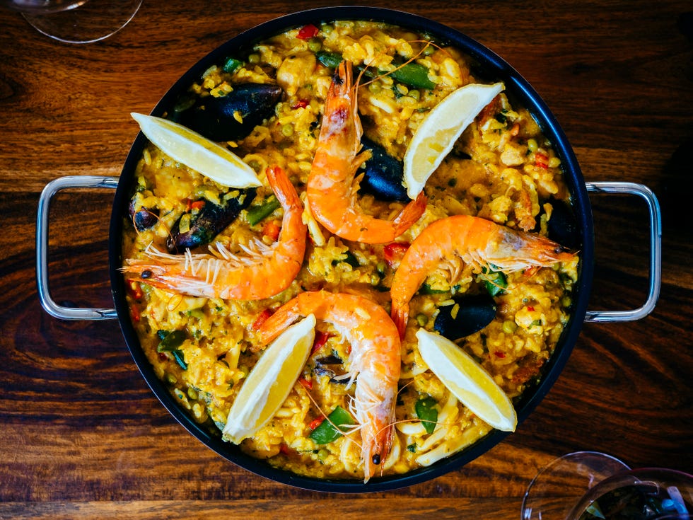 fresh paella in pan on wooden table