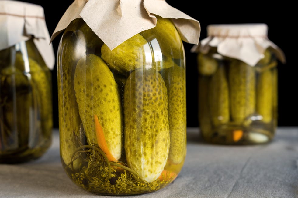 fresh pickled cucumbers on black background, homemade preserved vegetables