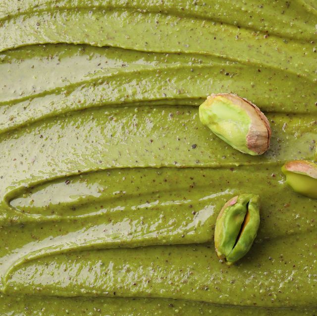 fresh pistachio nuts on tasty cream, above view