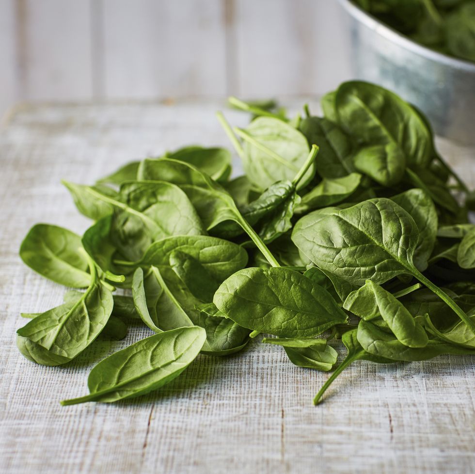 fresh spinach leaves on wood, colander
