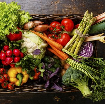fresh vegetables in basket on wooden background