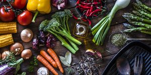 fresh vegetables ready for cooking shot on rustic wooden table