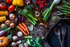 fresh vegetables ready for cooking shot on rustic wooden table