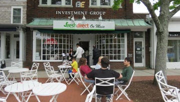 outdoor seating area in front of a freshdirect store