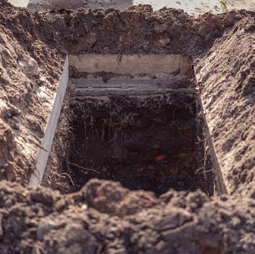 freshly dug grave pit at cemetery, a close up