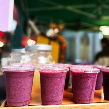Freshly made fruit smoothies in a row at the food market, Borough Market, UK