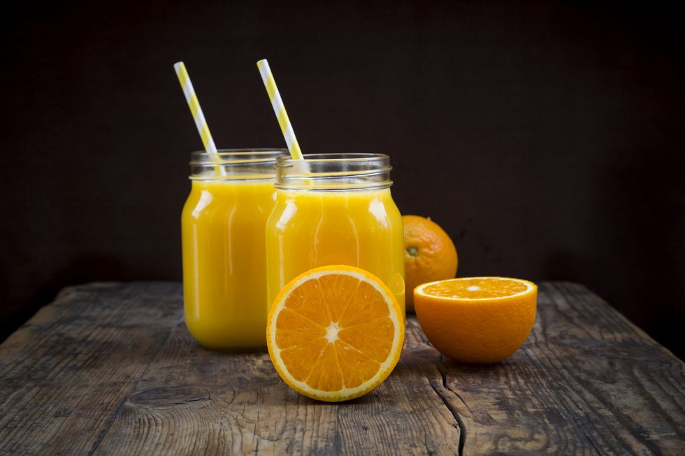 Freshly squeezed orange juice in jars with straws