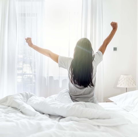 freshly woken up young woman enjoying the morning sun rays.