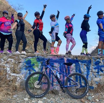 group portrait on a wall with a bike of fridas en bici