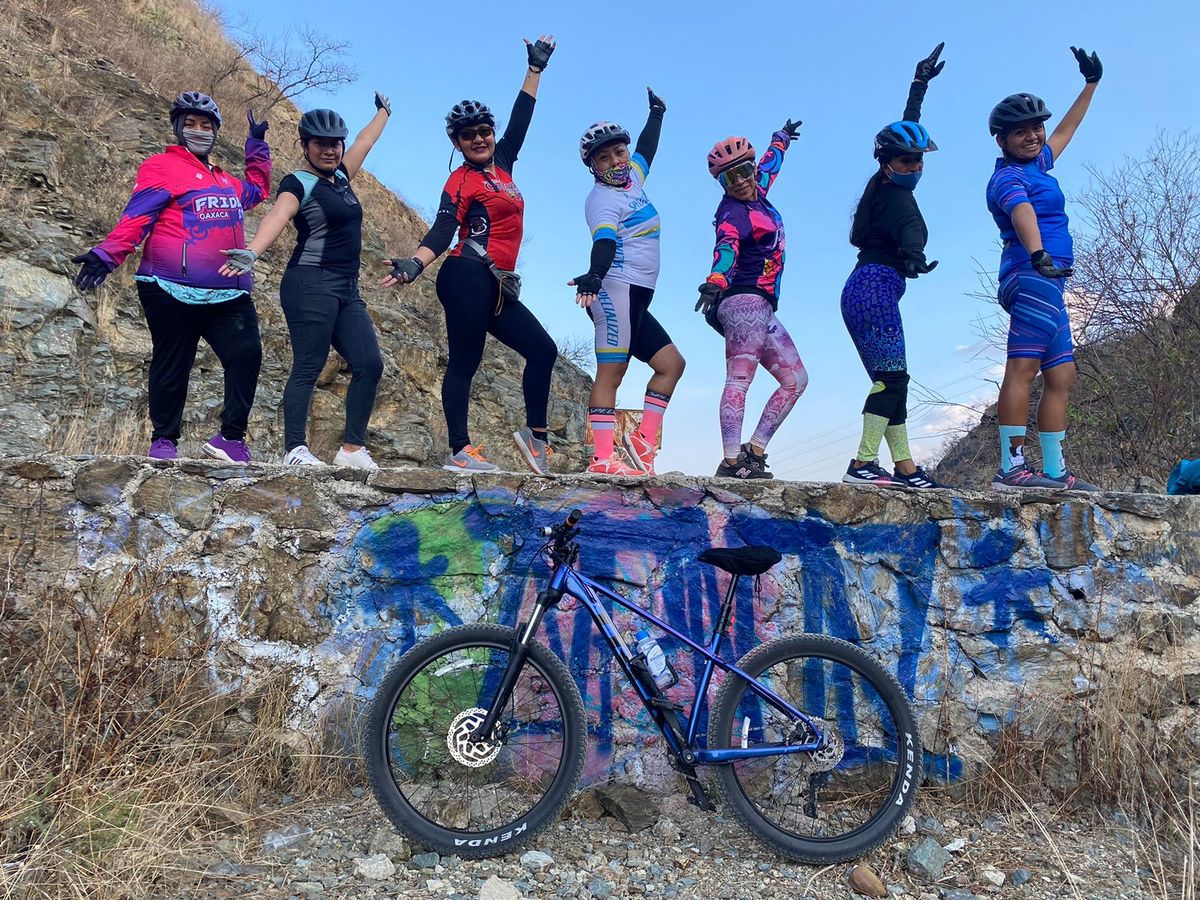 group portrait on a wall with a bike of fridas en bici