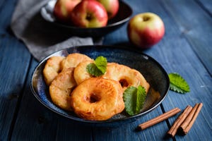 schaaltje met gebakken appelringen, appels en kaneelstokjes