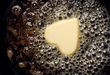 Fried butter, a piece of butter in the shape of hearts, fried on a black cast-iron pan.