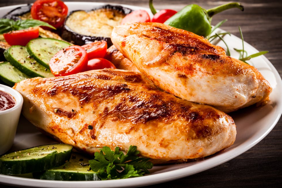 fried chicken fillets and vegetables on wooden background