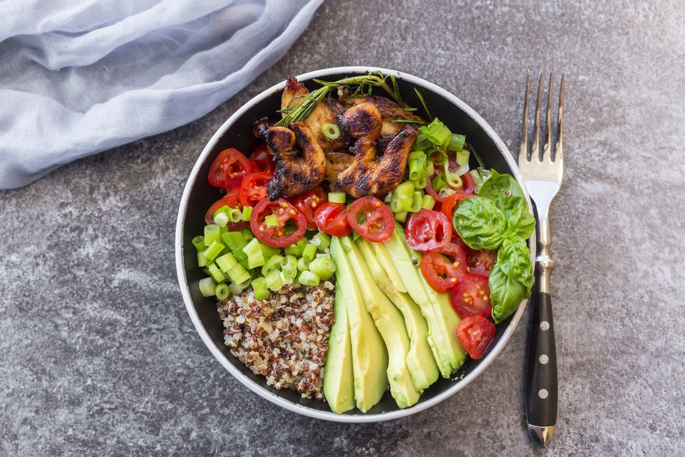 fried chicken, quinoa, tomato, avocado, spring onion, rosemary and basil in bowl