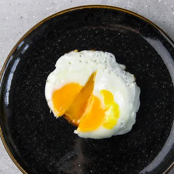 fried egg toast on black plate on gray concrete background