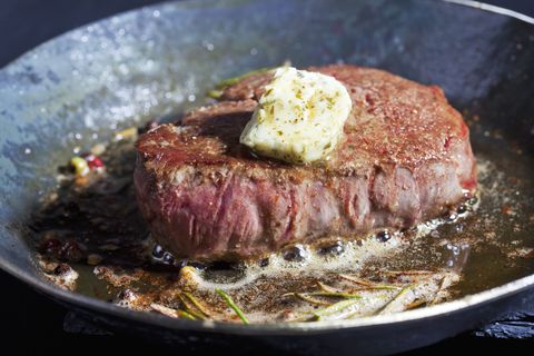 Fried fillet of beef with herb butter, peppercorns and rosemary in a pan