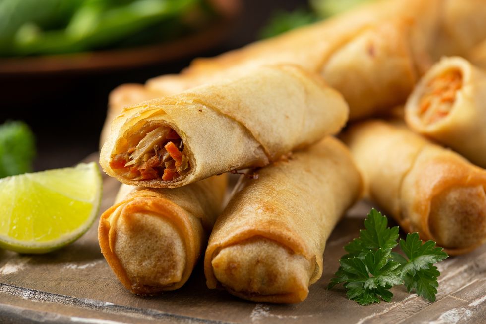 fried vegetable spring rolls with sweet chili and soya sauce on wooden board