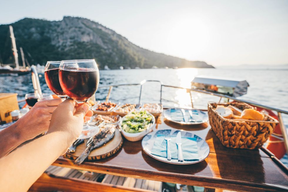friend drinking wine on the yacht at sunset toasting on a yacht