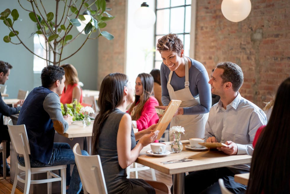 friendly waitress serving couple at a restaurant