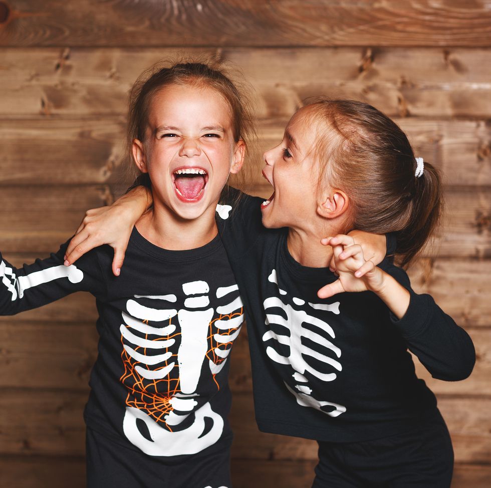 friends on halloween wearing matching skeleton shirts
