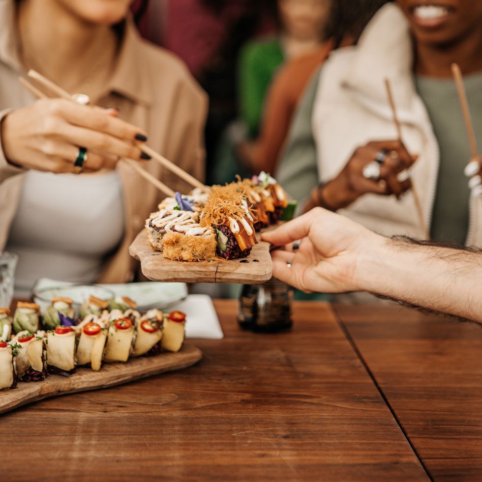friends enjoying sharing vegan sushi in a local restaurant