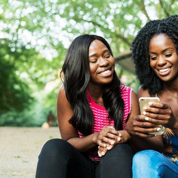 Friends laughing sharing on smart phone. Friends laughing sharing on smart phone.