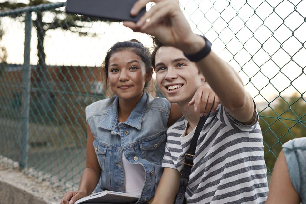 couple taking a selfie outside of school