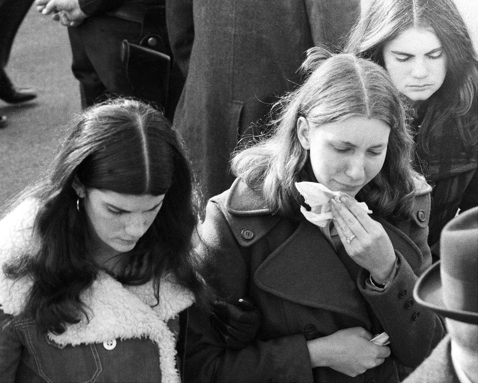 three young women weeping outside of st martin of tours catholic church in amityville
