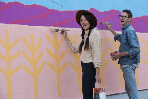 friends painting mural wall outdoors
