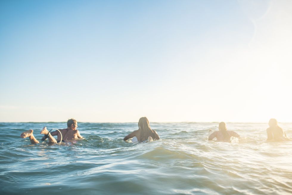 friends preparing to surf in the ocean