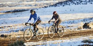 friends riding gravel bikes on dirt trail on winter evening