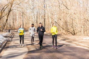 Friends running on a road in a park