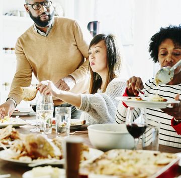 order thanksgiving dinner 2022  family passing food around at thanksgiving dinner table