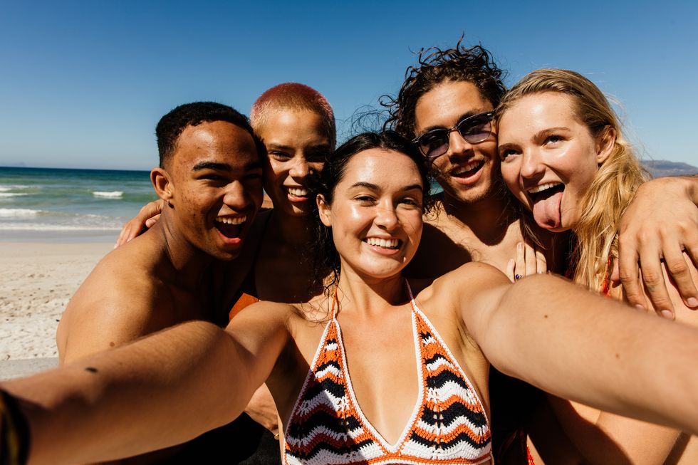 Friends taking a selfie of themselves on the beach
