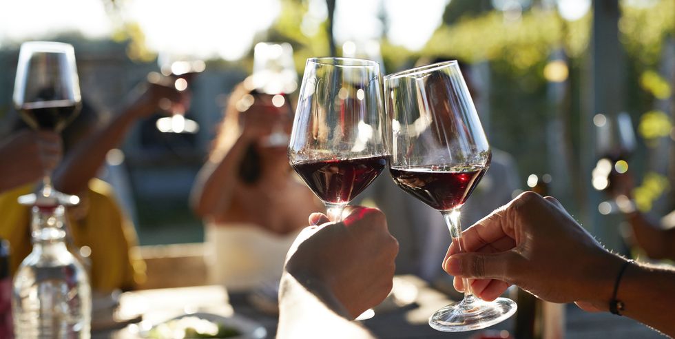 friends toasting glasses with red wine in wedding