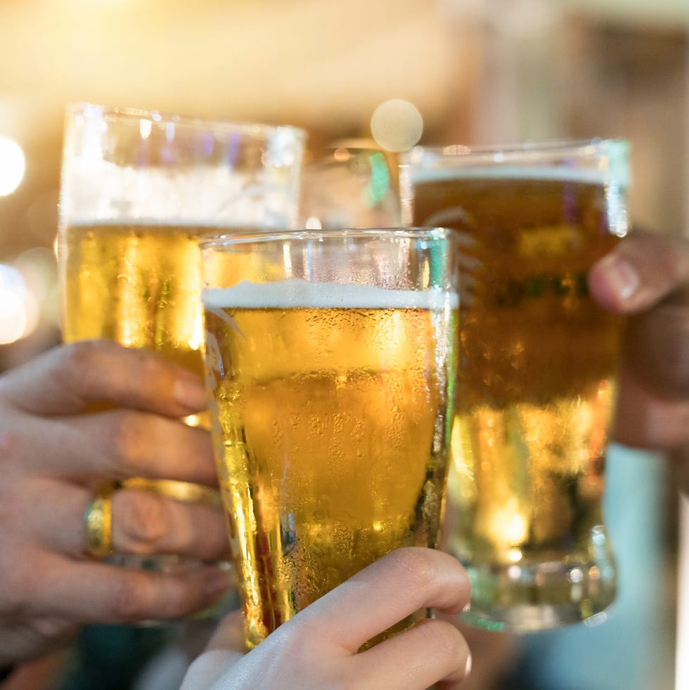 Friends toasting with glasses of light beer at the pub. Beautiful background of the Oktoberfest. A group of young people while relaxing at the bar. fine grain. Soft focus. Shallow DOF. Friends toasting with glasses of light beer at the pub. Beautiful background of the Oktoberfest. A group of young people while relaxing at the bar. fine grain. Soft focus. Shallow DOF.