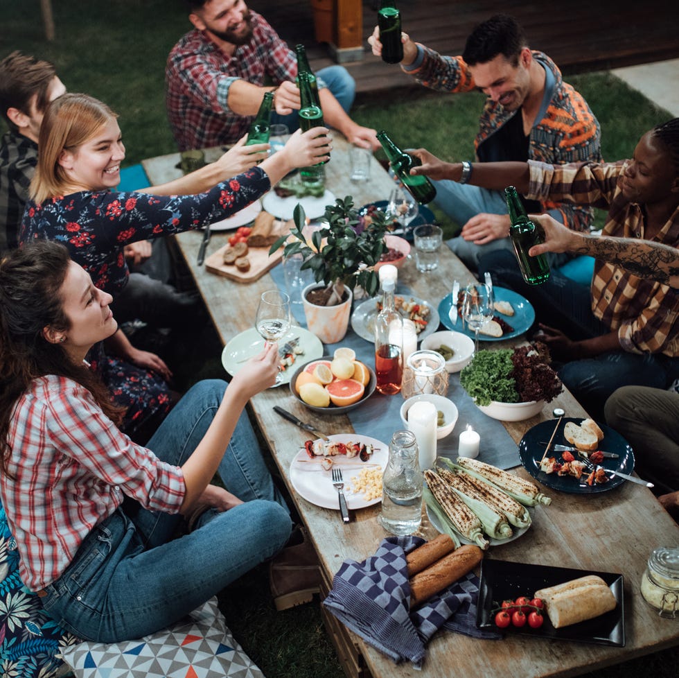 Friends toasting with wine and beer at rustic dinner party friends toasting with wine and beer at rustic dinner party