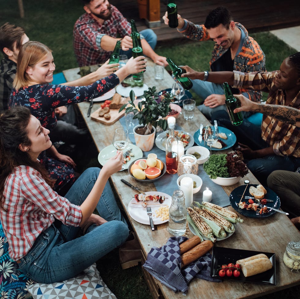 friends toasting with wine and beer at rustic dinner party